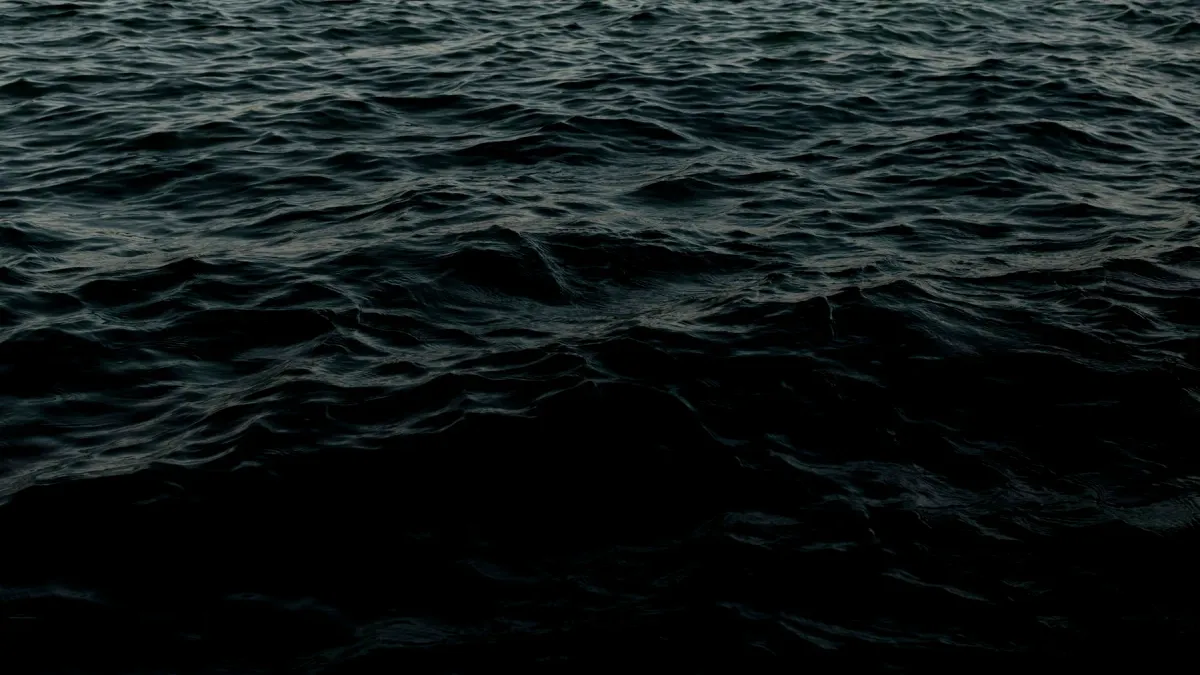 Dark deep-ocean water fading into black