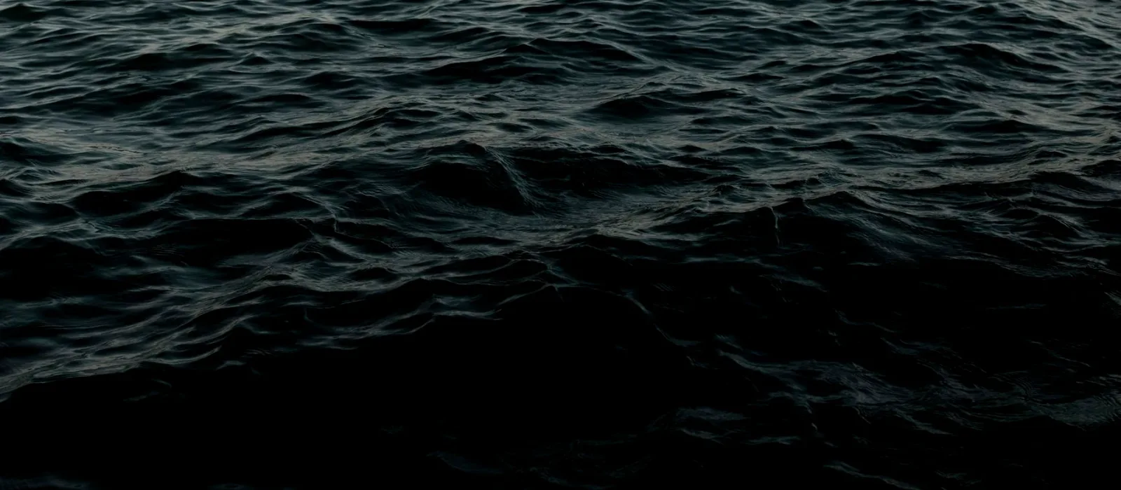 Dark deep-ocean water fading into black