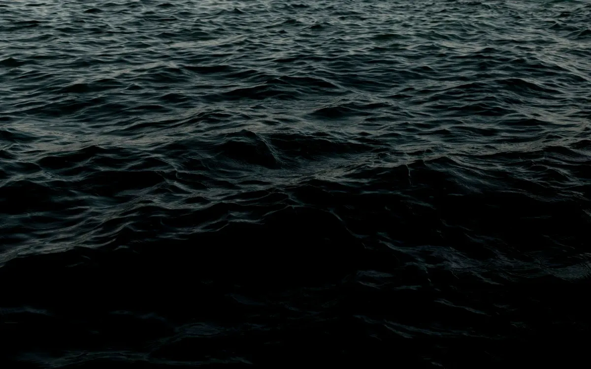 Dark deep-ocean water fading into black