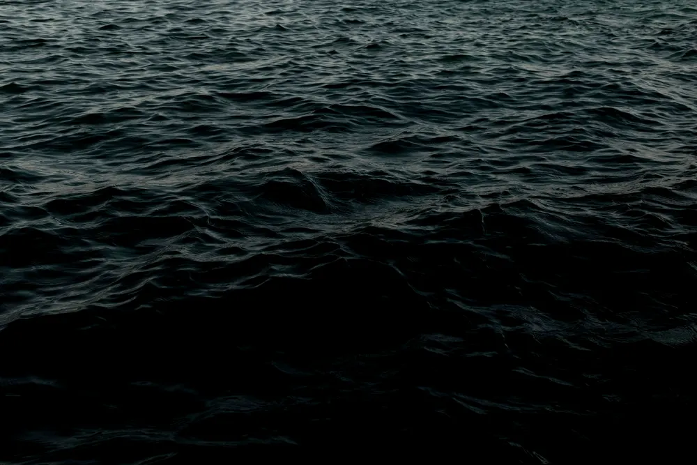 Dark deep-ocean water fading into black