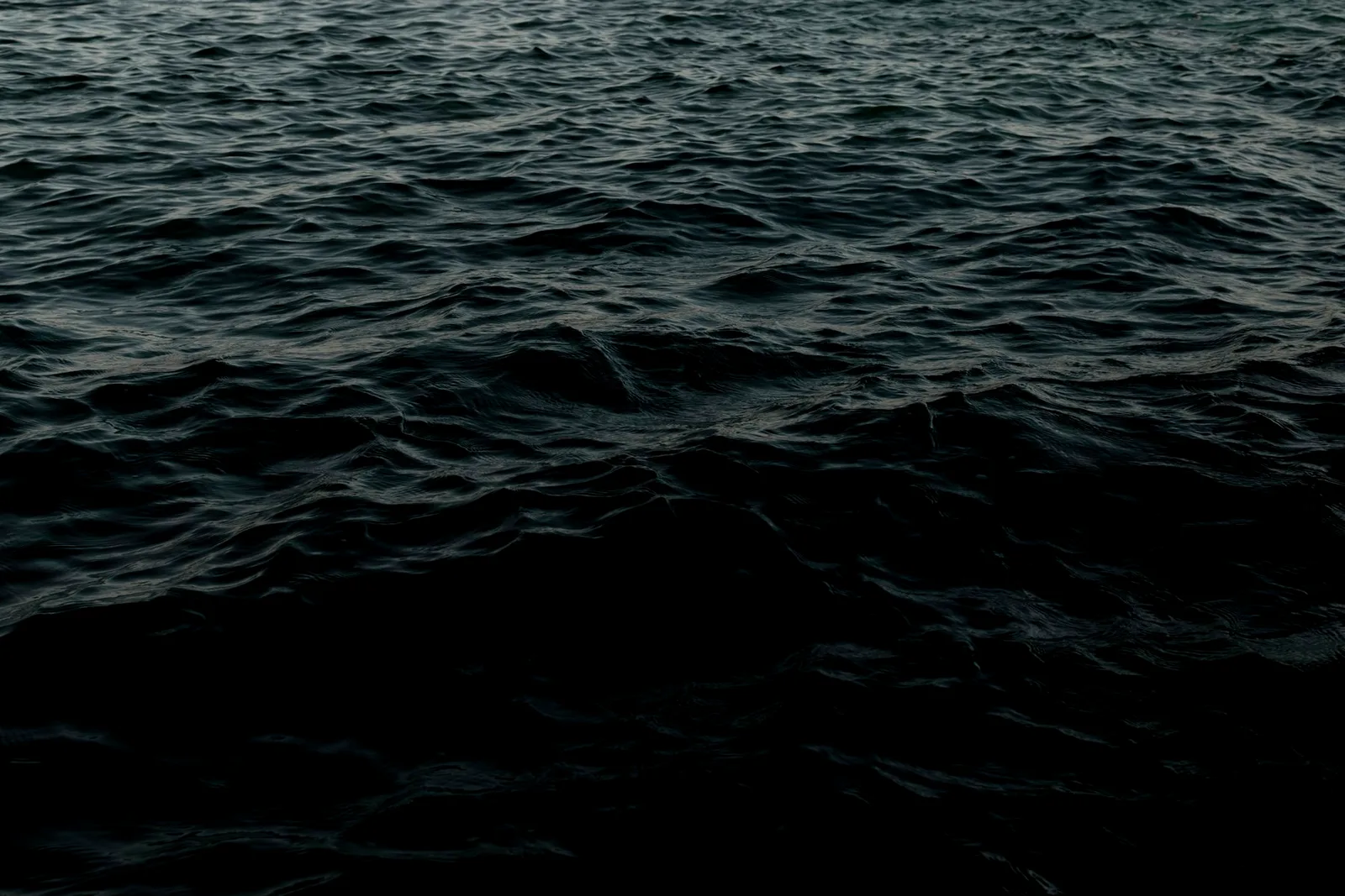 Dark deep-ocean water fading into black